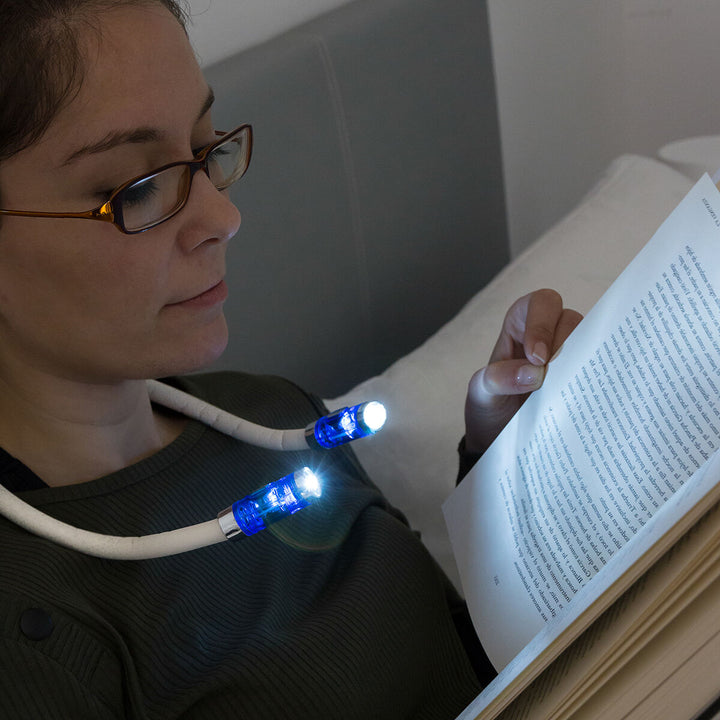 Frau liest Buch im Bett mit flexibler LED Leselampe um Hals - homely Family Shop