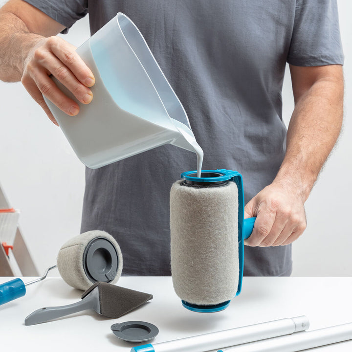 Mann füllt Farbe in nachfüllbare Farbrolle. Anti-Tropf Roll'n'paint Set mit Zubehör.