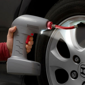 Grauer, tragbarer Luftkompressor mit LED pumpt einen Reifen auf. Airpro+ mit rotem Schlauch.