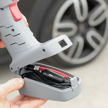 Grauer Airpro+ Luftkompressor mit LED. Fach zeigt Kabel und Adapter. Tragbarer Kompressor.