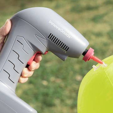 Grauer, tragbarer Luftkompressor Airpro+ von InnovaGoods pumpt einen grünen Ball auf.