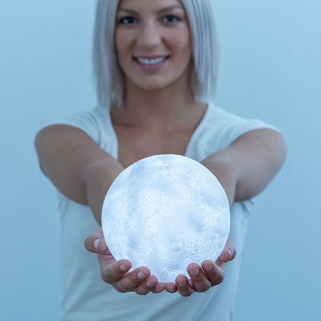 Frau hält LED Mond Lampe Moondy von InnovaGoods - homely Family Shop