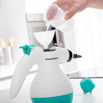 Weißer InnovaGoods Steany Handdampfreiniger wird mit Zubehör und Trichter mit Wasser befüllt.