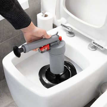 InnovaGoods KlinGun Abflussreiniger im Einsatz. Graue Druckluftpistole mit Adaptern zur Rohrreinigung.