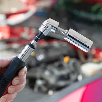 InnovaGoods Uniscrew Universalsteckschlüssel im Einsatz am Motorraum, Silber und Schwarz.